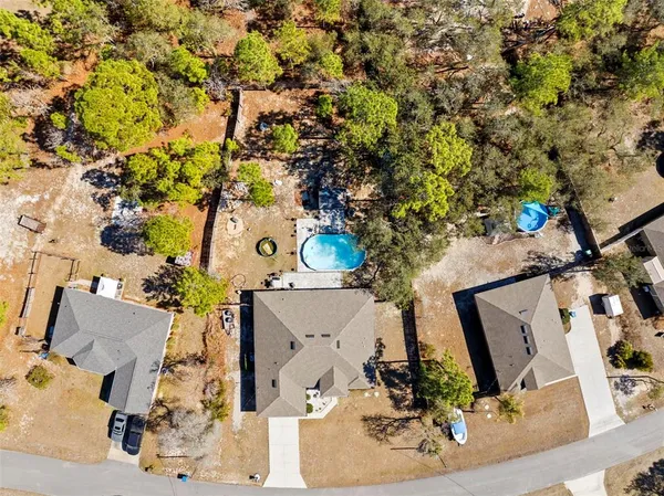 an aerial view of residential houses with outdoor space and parking