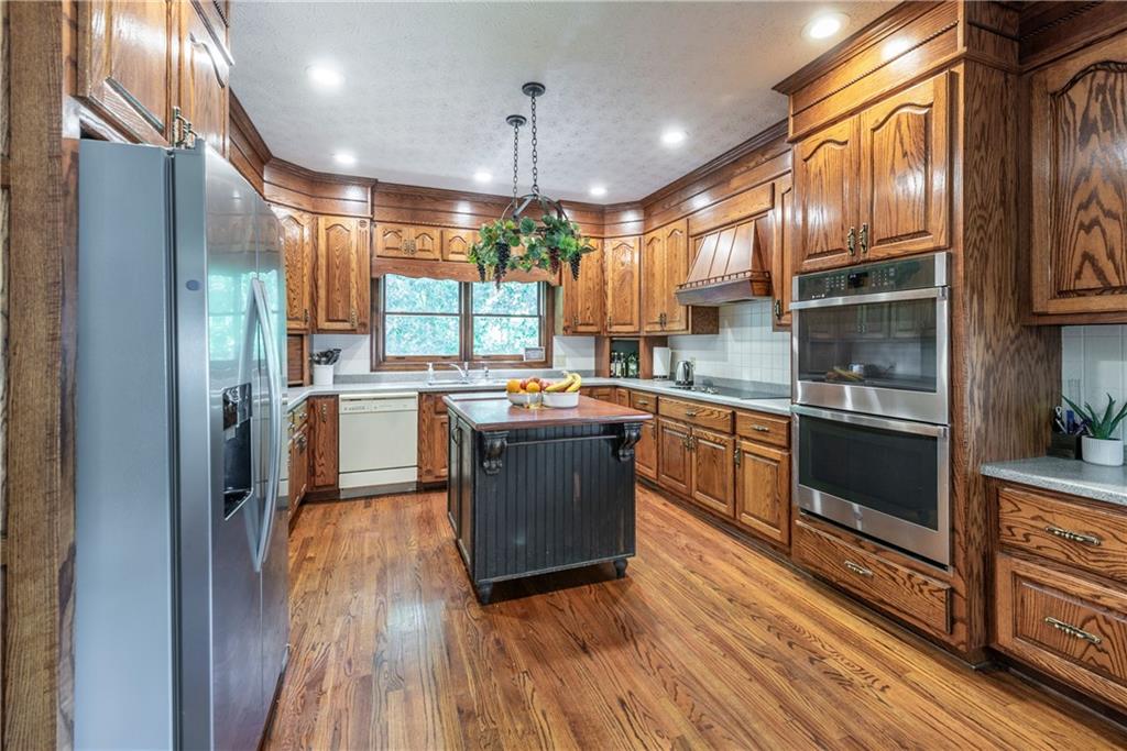 755 Harris Road Jasper, GA 30143 - Photo 25 of 60 a kitchen with stainless steel appliances granite countertop wooden cabinets a refrigerator a sink a stove and a wooden floors