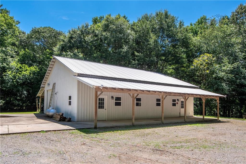 755 Harris Road Jasper, GA 30143 - Photo 47 of 60 a view of a white house with a large tree and plants