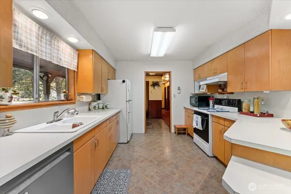 a large kitchen with stainless steel appliances kitchen island granite countertop a sink and cabinets