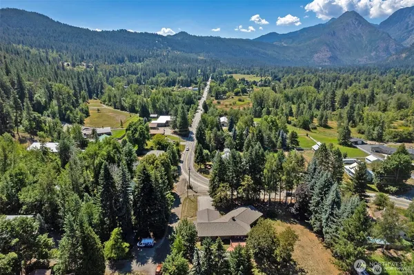 an aerial view of house with yard and mountain view in back