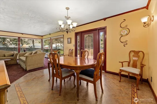 a view of a dining room with furniture a chandelier and wooden floor