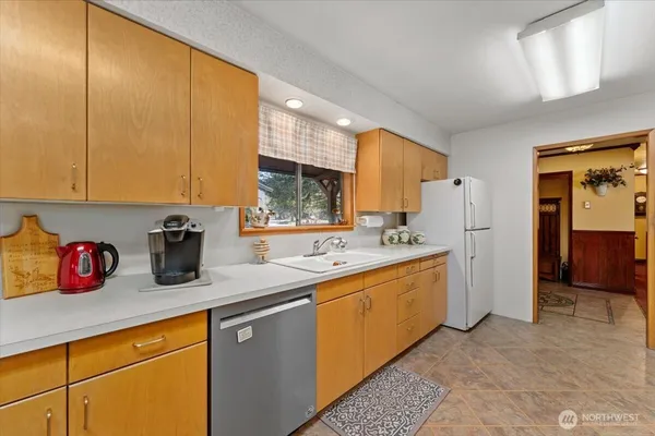 a kitchen with a sink a refrigerator and cabinets