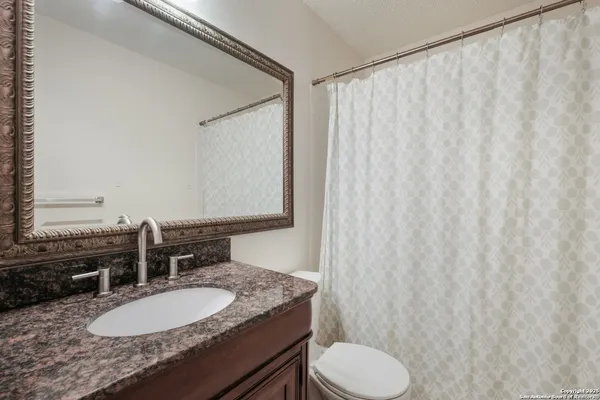 a bathroom with a granite countertop sink and a mirror