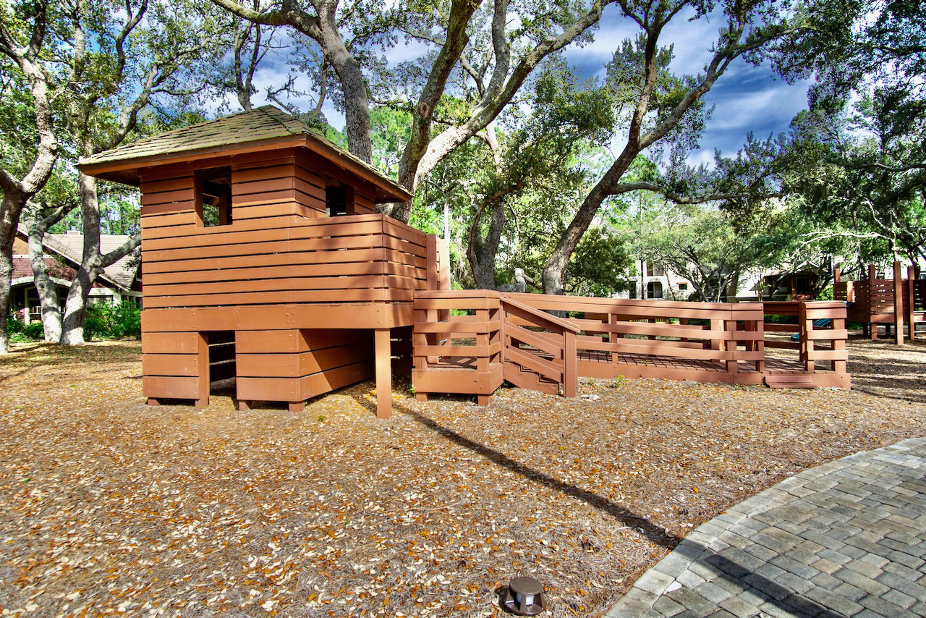 1508 Match Point Lane, Unit 302 Panama City Beach, FL 32413 - Photo 60 of 76 a view of a house with a yard chairs and a large tree