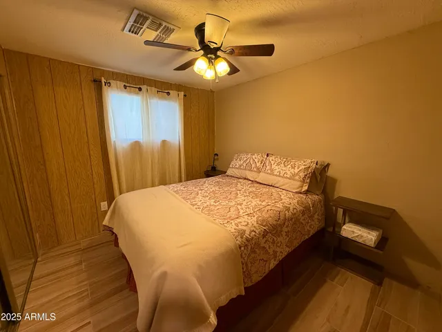 a bed sitting in a spacious bedroom next to a window
