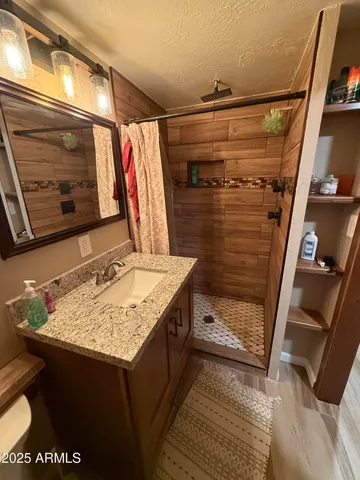 a bathroom with a granite countertop sink and a mirror