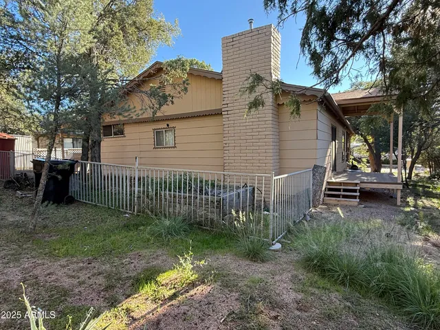 a view of backyard with outdoor seating and wooden fence