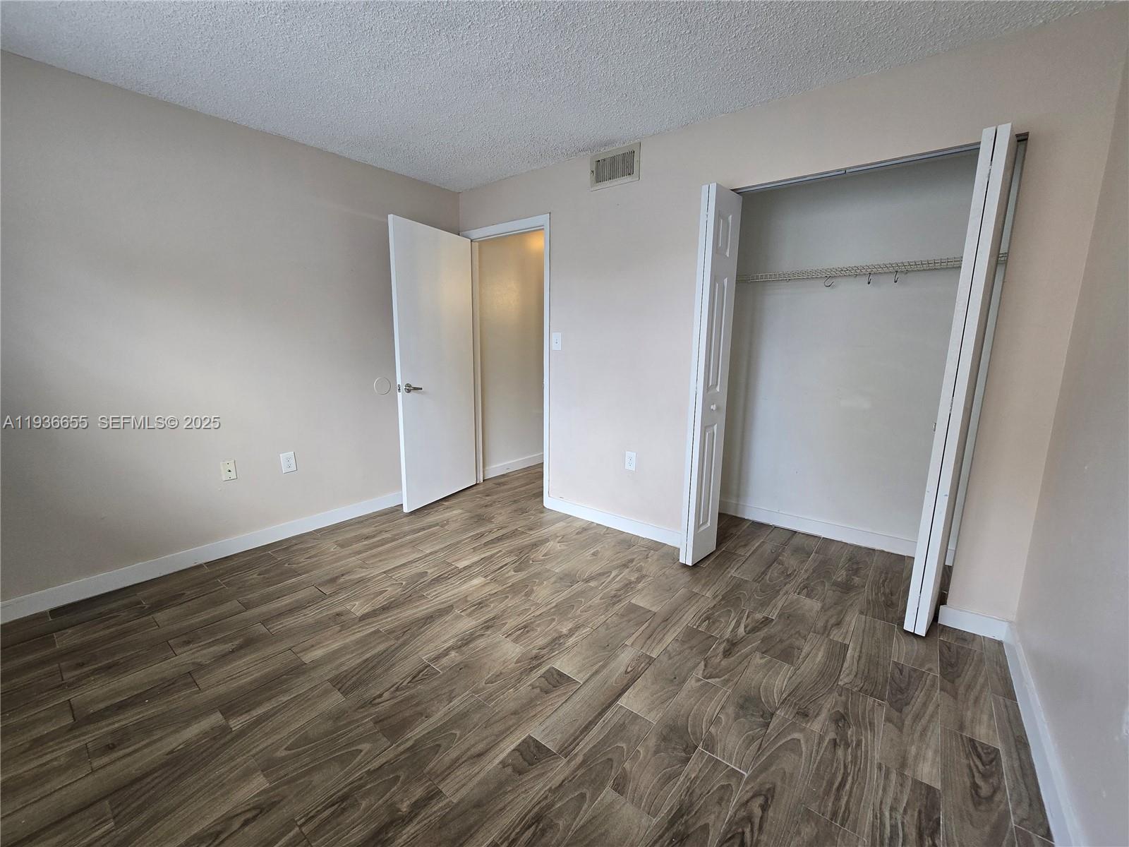 2153 Southwest 80th Terrace, Unit 2153 Miramar, FL 33025 - Photo 11 of 15 a view of an empty room with wooden floor and closet