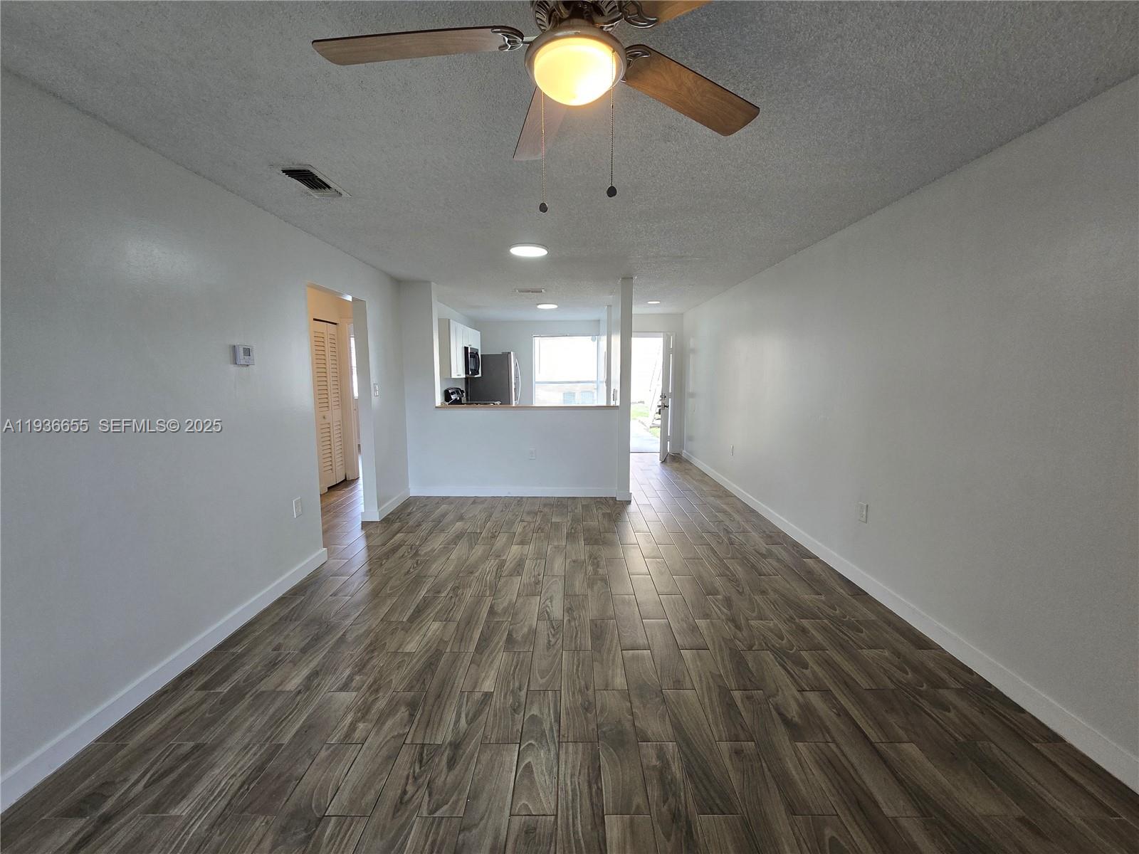 2153 Southwest 80th Terrace, Unit 2153 Miramar, FL 33025 - Photo 2 of 15 a view of an empty room with wooden floor and a window
