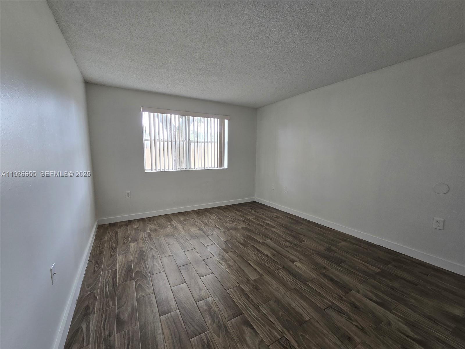 2153 Southwest 80th Terrace, Unit 2153 Miramar, FL 33025 - Photo 6 of 15 an empty room with wooden floor and windows