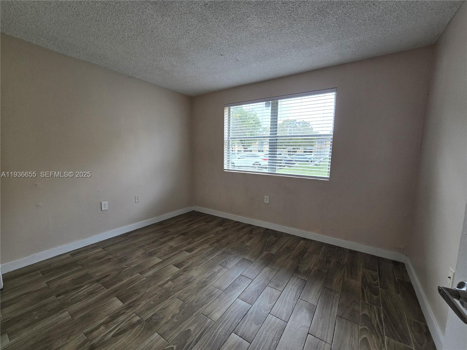 2153 Southwest 80th Terrace, Unit 2153 Miramar, FL 33025 - Photo 10 of 15 a view of an empty room with wooden floor and a window