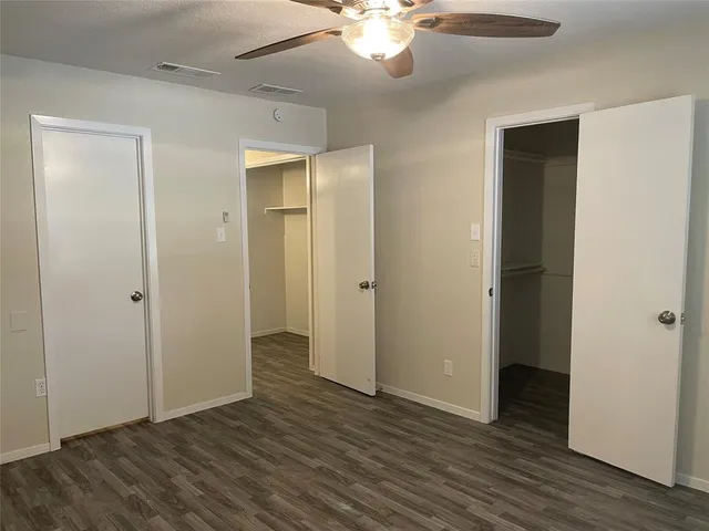 an empty room with wooden floor and closet area