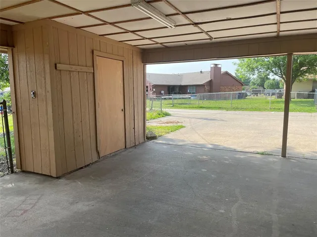a view of a room with a big yard and large tree