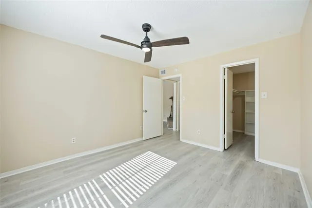 a view of room with wooden floor and ceiling fan