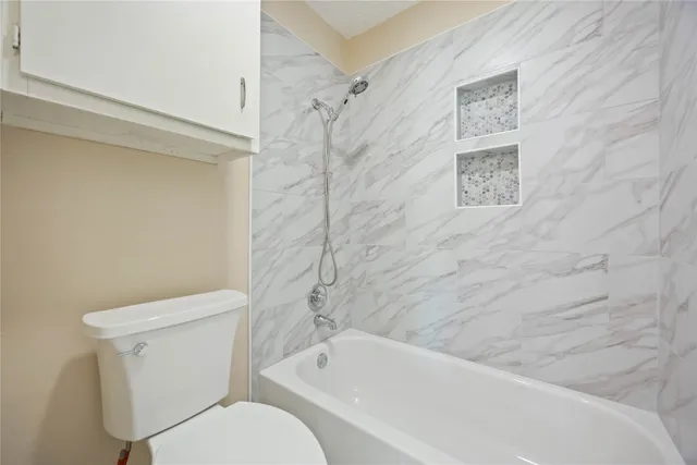 a white toilet sitting next to a bath tub