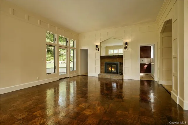 a view of an empty room with window and fire place