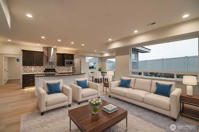 a living room with furniture kitchen view and a wooden floor