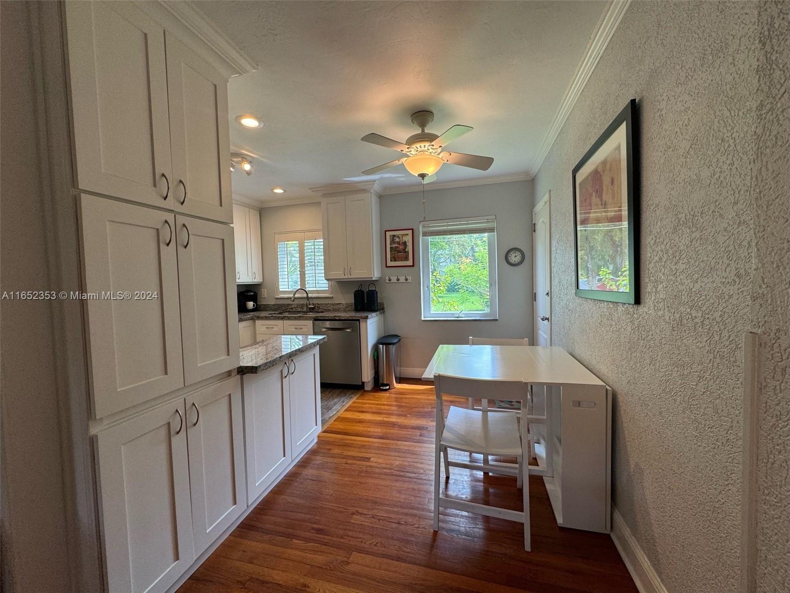 5530 Southwest 76th Street, Unit A Miami, FL 33143 - Photo 2 of 10 a kitchen with kitchen island granite countertop a refrigerator and a stove top oven
