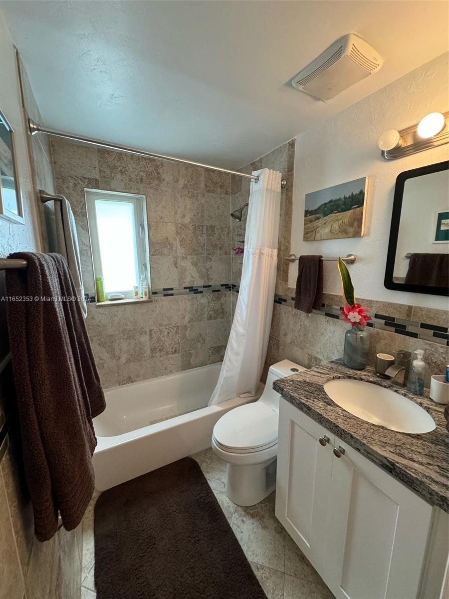 5530 Southwest 76th Street, Unit A Miami, FL 33143 - Photo 8 of 10 a bathroom with a sink a toilet a tub and shower