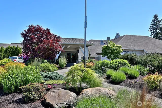 a front view of a house with a garden and yard