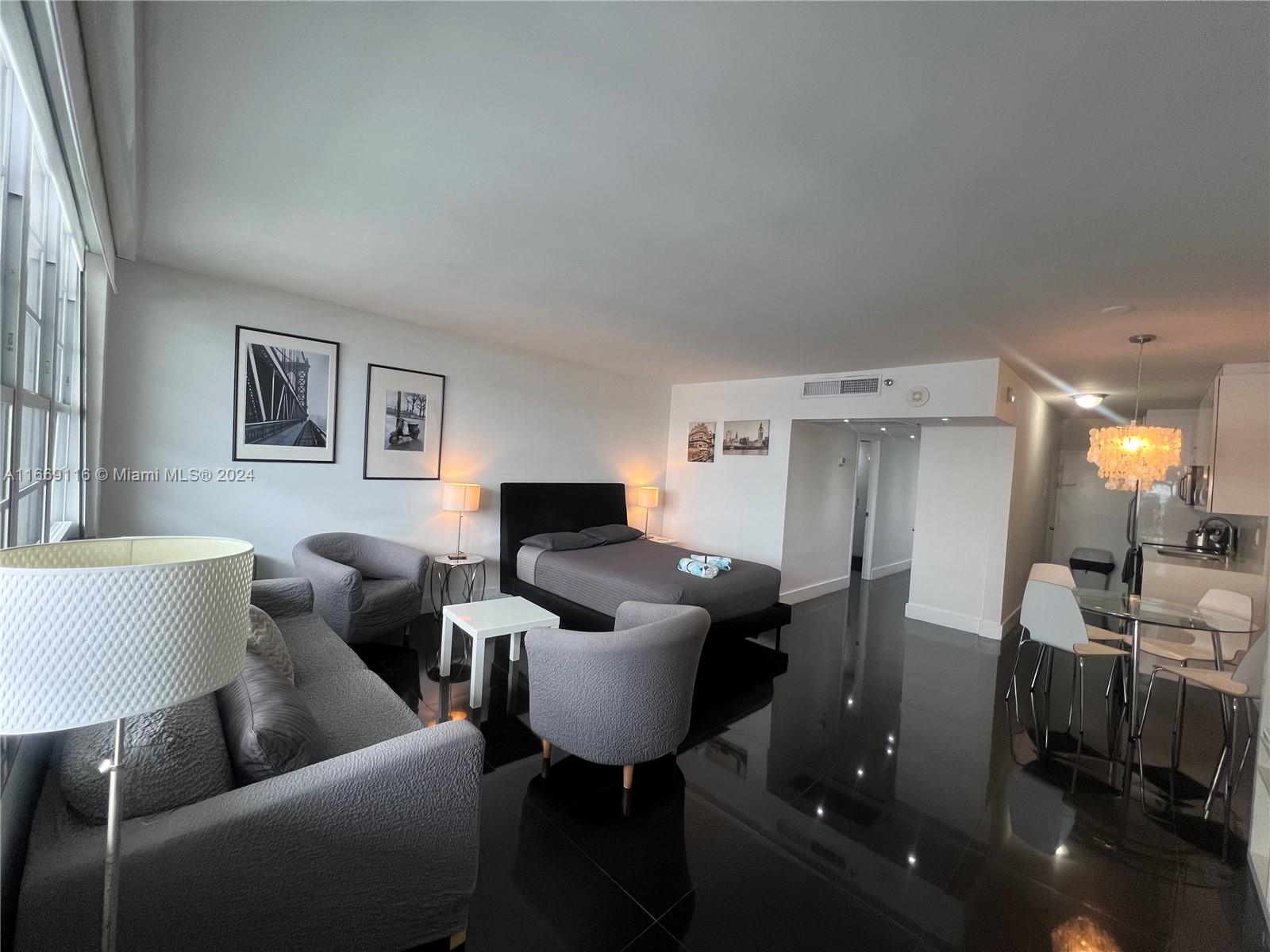 100 Lincoln Road, Unit 1418 Miami Beach, FL 33139 - Photo 3 of 18 a living room with furniture and a lamp