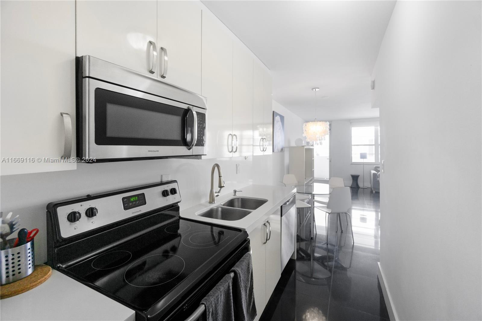 100 Lincoln Road, Unit 1418 Miami Beach, FL 33139 - Photo 7 of 18 a kitchen with a stove and a microwave