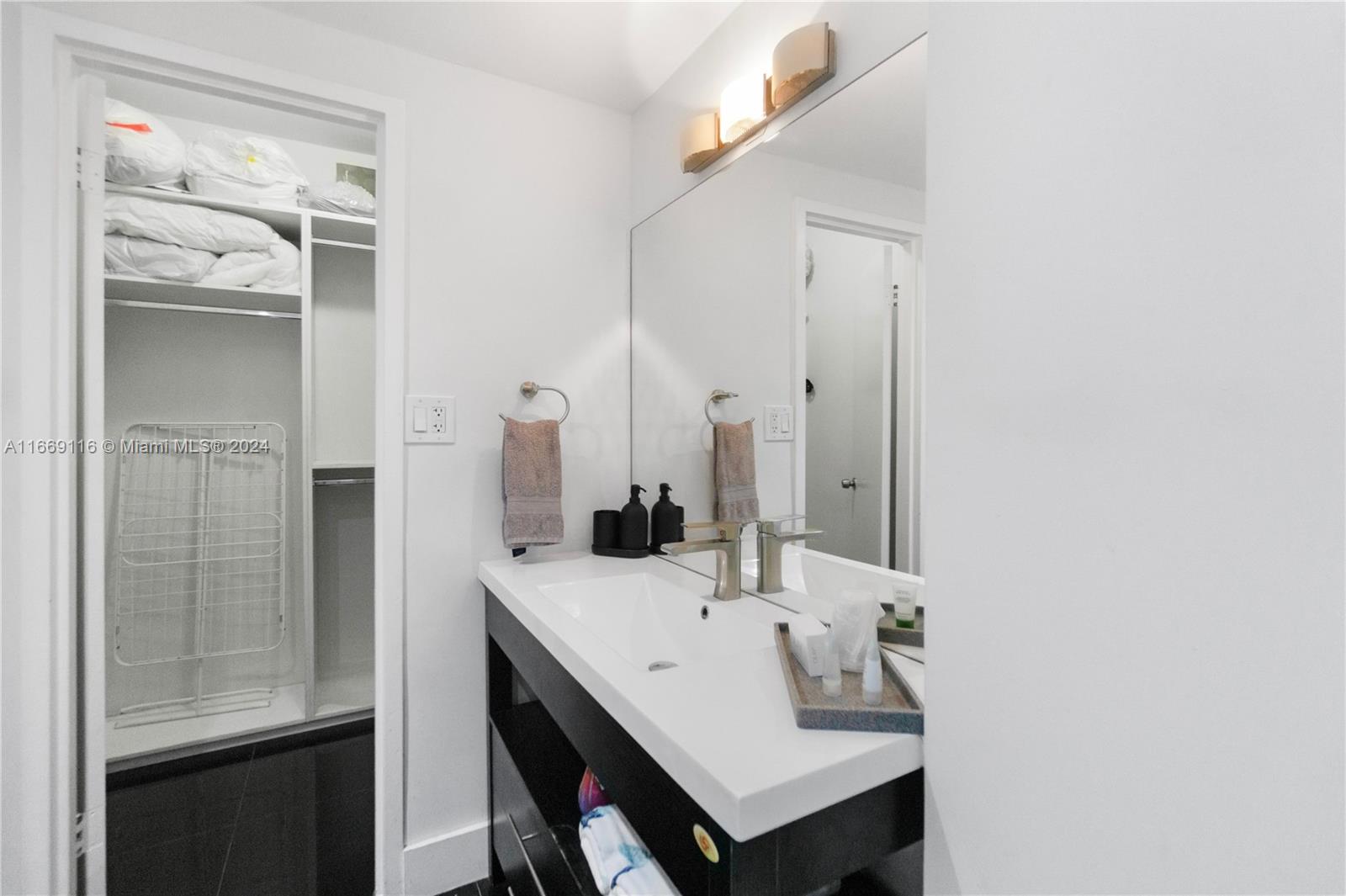 100 Lincoln Road, Unit 1418 Miami Beach, FL 33139 - Photo 9 of 18 a bathroom with a sink and a mirror