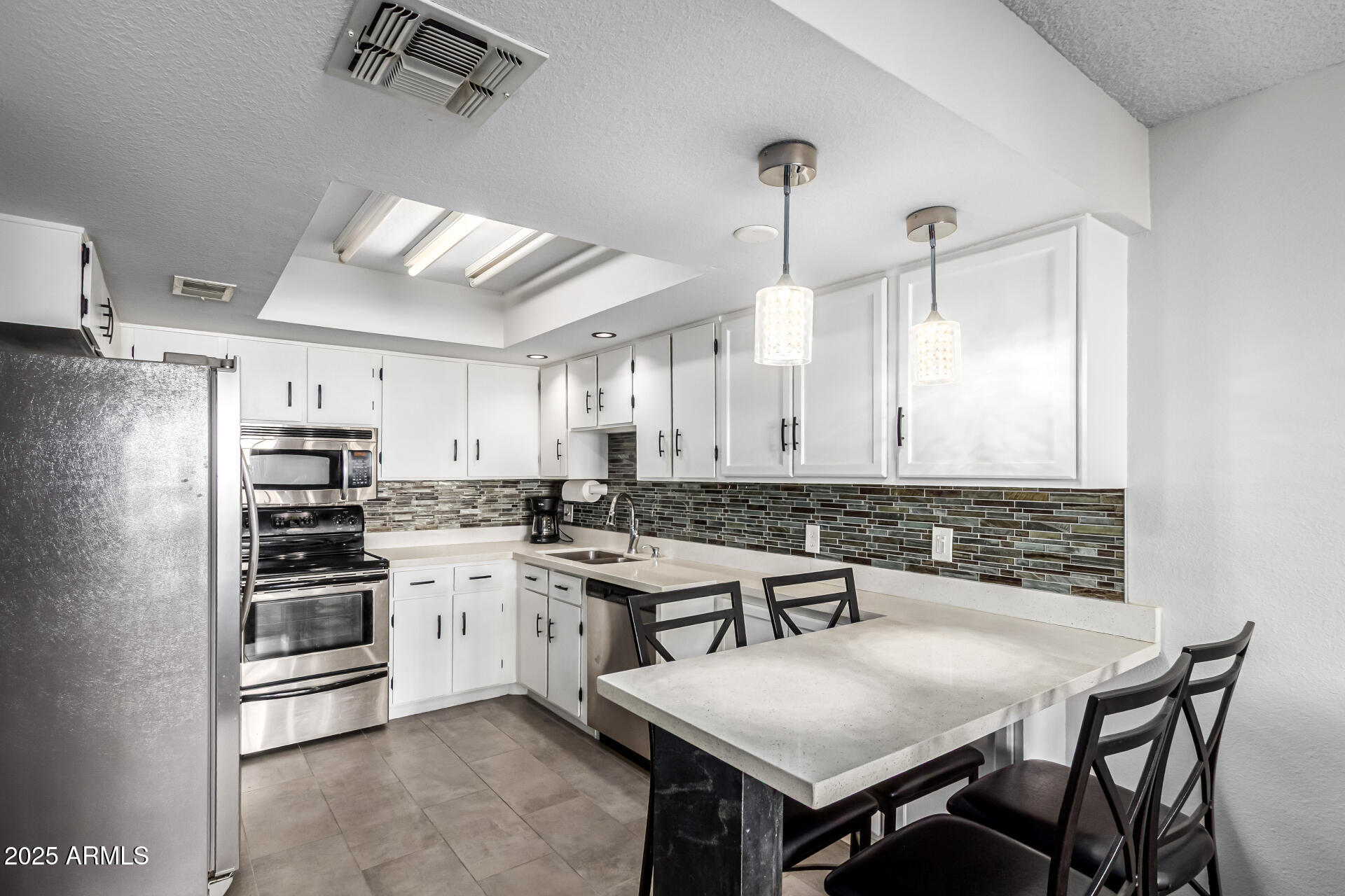 7910 East Camelback Road, Unit 203 Scottsdale, AZ 85251 - Photo 3 of 12 a kitchen with a stove a sink and chairs