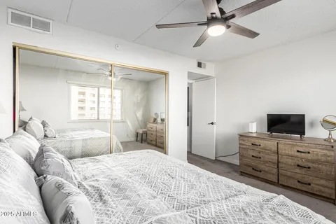 a bedroom with a large bed and a flat tv screen on dresser