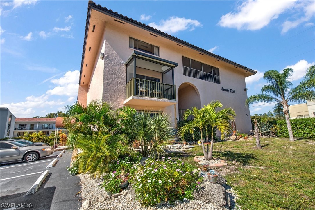 828 Wiggins Pass Road, Unit 10 Naples, FL 34110 - Photo 1 of 17 a front view of a house with garden