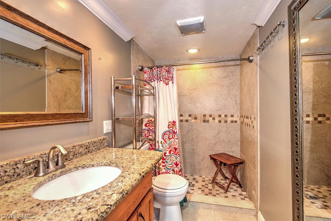 828 Wiggins Pass Road, Unit 10 Naples, FL 34110 - Photo 14 of 17 a bathroom with a granite countertop sink toilet and shower