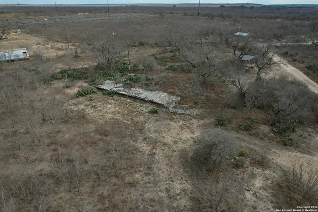 a view of a dry yard with wooden fence
