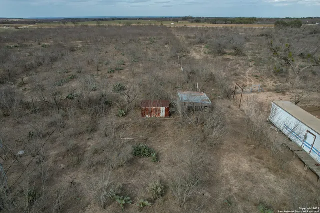 a view of a dry yard with wooden floor and fence