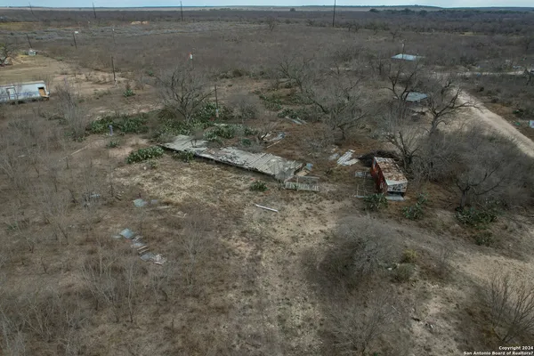 a view of a dry yard with trees