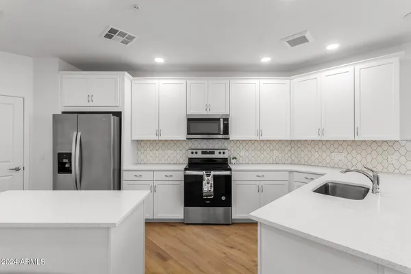 a kitchen with a sink a stove and cabinets