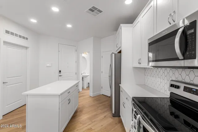 a kitchen with a dining table chairs refrigerator and microwave