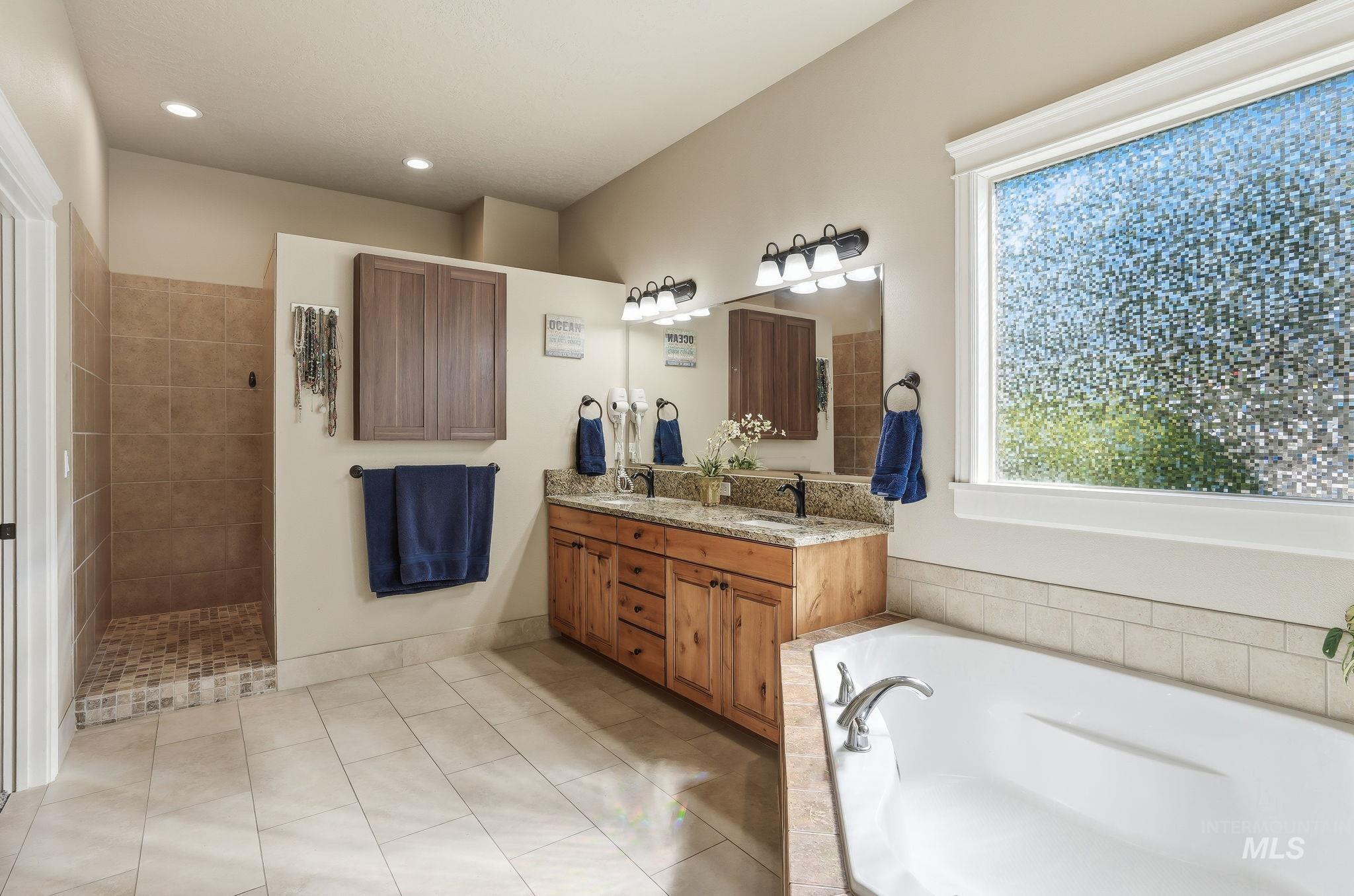 3969 North Hollymount Way Meridian, ID 83646 - Photo 24 of 47 Bathroom featuring a dual vanity with granite countertop, wood-finish cabinetry, and framed mirrors