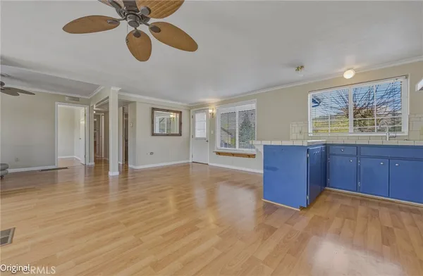 a view of an empty room with window and wooden floor