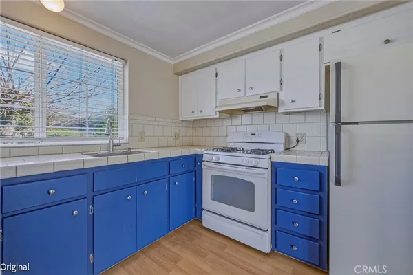 a kitchen with stainless steel appliances granite countertop a refrigerator and a stove top oven