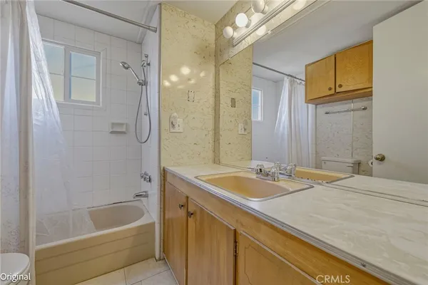 a bathroom with a granite countertop tub sink and mirror