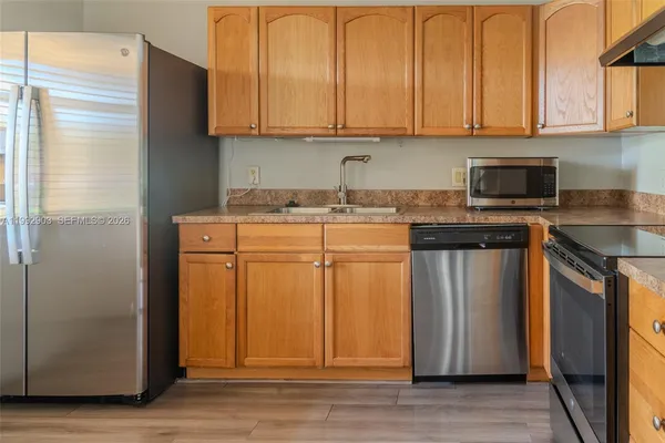 a kitchen with stainless steel appliances granite countertop a stove a refrigerator and a sink