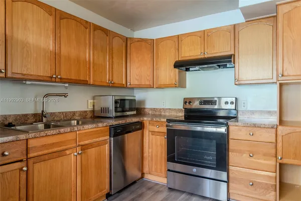 a kitchen with granite countertop wooden cabinets and a stove top oven