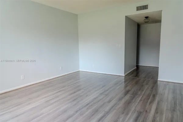 an empty room with wooden floor and closet