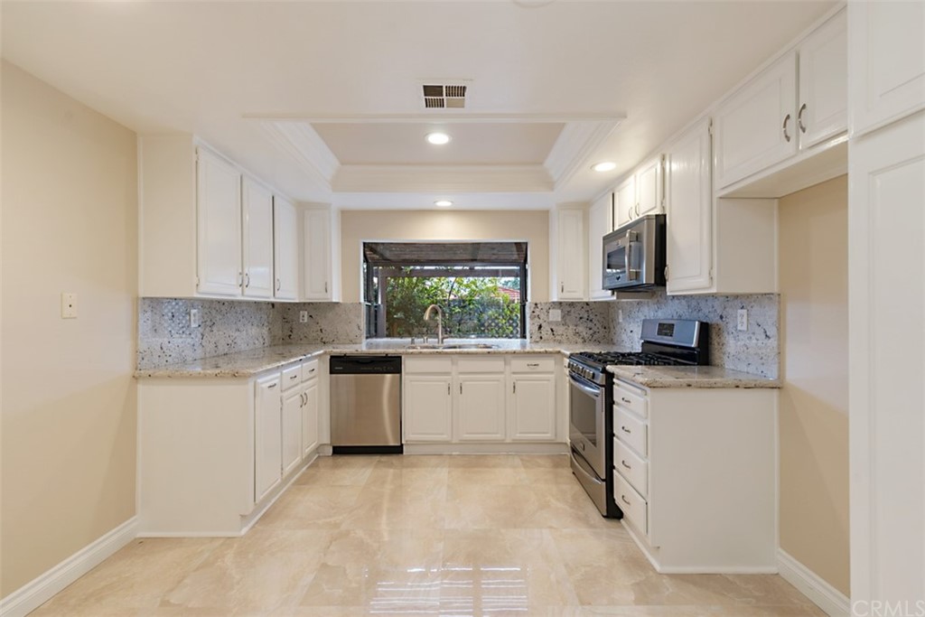 25666 Seaside Drive, Unit 134 Dana Point, CA 92629 - Photo 5 of 13 a kitchen with a white cabinets and window