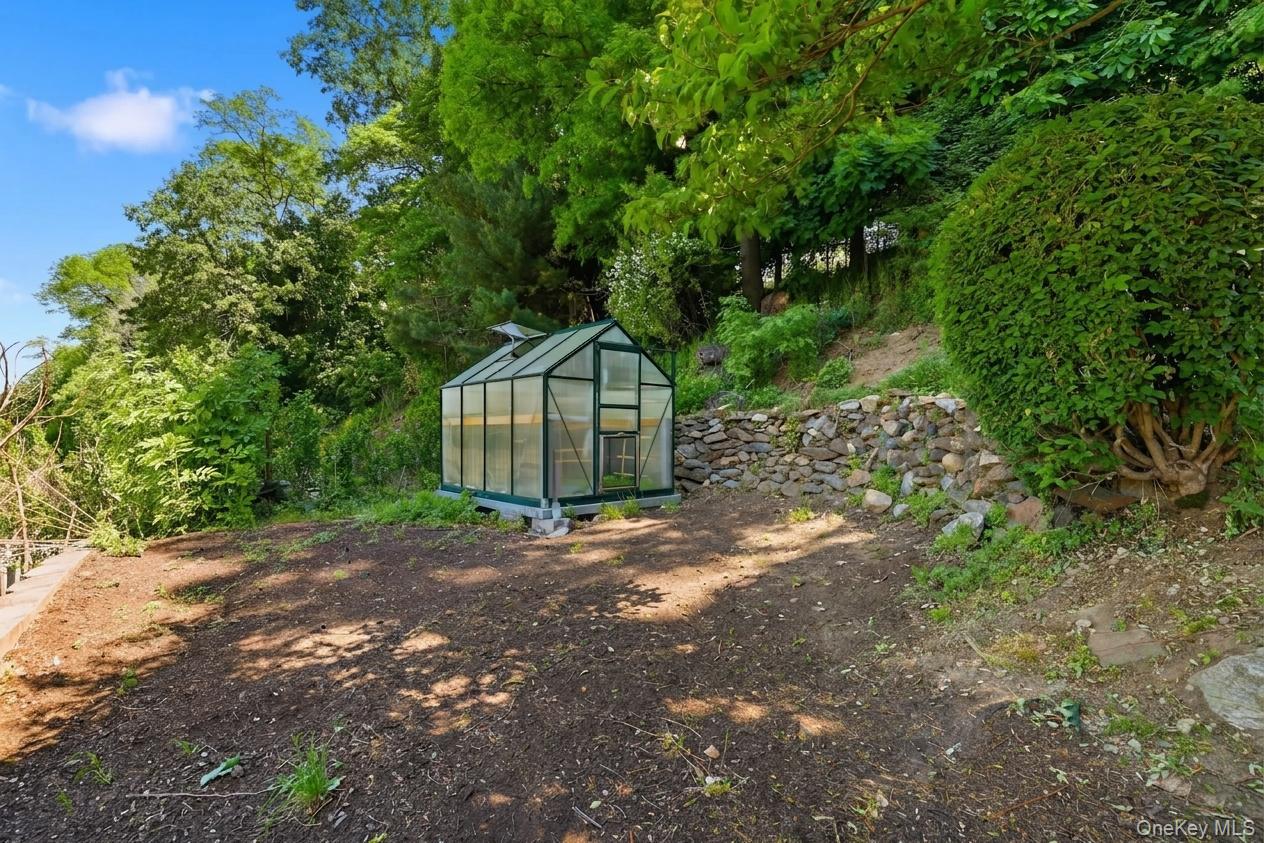 29 Montrose Road Yonkers, NY 10710 - Photo 32 of 39 Standalone greenhouse structure with a sloped glass roof and clear paneling