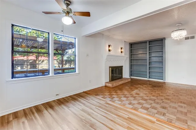 a view of an empty room with a window and fireplace