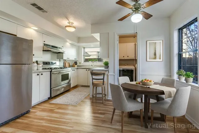 a kitchen with a dining table chairs refrigerator and cabinets