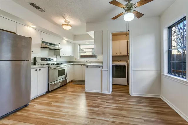 a kitchen with stainless steel appliances granite countertop a refrigerator a stove a sink and a microwave