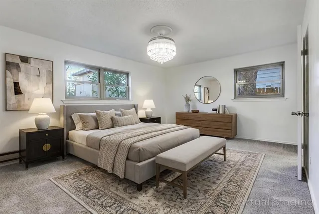 a spacious bedroom with a bed and a chandelier